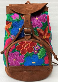 a brown backpack with colorful flowers painted on it