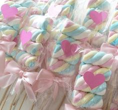 some lollipops wrapped in pink, blue and yellow with hearts on them