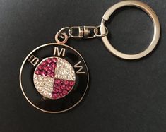 a metal key chain with a red and white cross in the center on a black surface