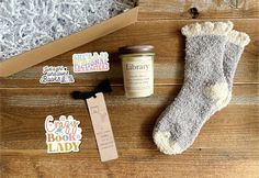 the contents of a gift box including socks, candle and stickers on a wooden floor