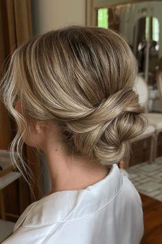 a woman with blonde hair styled into a low bun