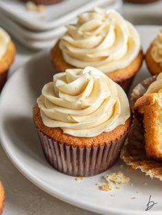 several cupcakes with frosting on a white plate