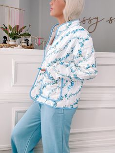 Wrap yourself in floral perfection with the Blue Floral Crest Quilted Jacket from Sassy Shortcake. This ivory, quilted jacket features a playful blue floral pattern and side pockets, all finished off with a blue lined hem. Stay warm and stylish in this fun jacket. content: 100% nylon care: hand wash cold fits true to size, model wearing size small Sassy Shortcake, Fun Jacket, Patriotic Dresses, Cold Fits, Blue Floral Pattern, Blue Quilts, Shoe Gifts, Cool Jackets, Blue Jacket