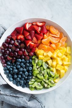 a white bowl filled with sliced fruit on top of a table next to a gray towel