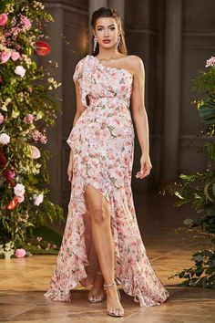 a model walks down the runway in a floral dress with one leg slited up