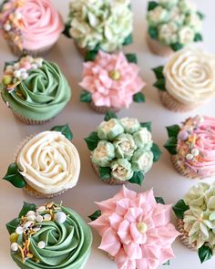 cupcakes decorated in pastel colors with flowers on them and leaves around the edges