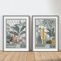 two framed posters with plants on them in front of a white wall and wooden floor