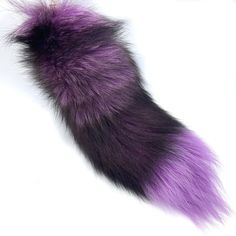 a purple and black furry animal tail on a white background with an orange tag hanging from it's end