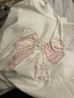 a white shirt with an embroidered bow on it