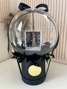 a christmas ornament with a photo in it on top of a black box