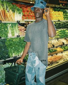 a man is talking on his cell phone while standing in front of a produce section