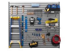 tools hanging up on a garage wall with hooks, wrenches, hoses and other items