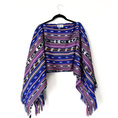 This lightweight yet cozy shawl is a modified version of our Santos Shawl. With the handmade fringe along the sleeves and the cropped length, this shawl will give you a chic look without having to compromise comfort. Guatemala Fabric Artisan: Don Manuel & Family Handwoven in Nahuala using the traditional weaving loom Material: Artisanal fabric is 100% cotton Peru Fabric Vendor: Sandra from Aguayos Cusco Manufactured in the Andes of Peru Material: Artisanal fabric is 100% acrylic wool Sewn by: Do One Size Fringe Shawl Cape, One Size Fringe Cape Shawl, Blue One-size Poncho With Fringe, Blue Fringe Poncho One Size, One Size Blue Poncho With Fringe, Weaving Loom, Traditional Weaving, Chic Look, Loom Weaving