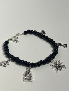 Bracelet made with Obsidian & Pewter Charms. Charms include ; Spider, Black Cat, Haunted Mansion, Witch, and Pumpkin Made to fit. For Reference, the bracelet in the photo is 7.5 inches long and will most.  If you have smaller wrist chose 7 inches to ensure snug fit, if male choose 8 inches Each item bought will be sent with an assortment of freebies! These could include ; raw crystal chunks, acrylic pins, bookmarks, travel lipsticks, and stickers!  Gift boxing is available per request! Created w Cat Spider, Halloween Charm Bracelet, Gothic Bracelet, Pumpkin Cat, Measure Ring Size, Hanging Necklaces, Acrylic Pins, Halloween Charms, Jewelry Black