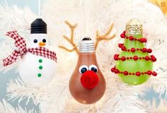 three christmas ornaments are hanging from a white tree with snowman, reindeer and light bulb decorations