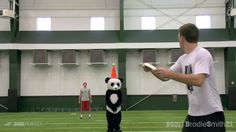 a man standing next to a panda mascot holding a nintendo wii controller in his hand