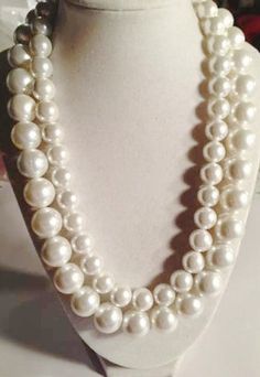 This pearl necklace created by Jewelry by CARMAL is made of: two sizes of white pearls, sterling silver hook and chain clasp and findings. This necklace measures 20 to 21 1/2 inches in length depending upon where you hook the clasp. The pearl is the birthstone of June. White is associated with light, goodness, innocence, purity, and virginity. It is considered to be the color of perfection. The pearl is also the gemstone for the 30th wedding anniversary! Pearls can be trendy or traditional and e Gray And White Pearl Necklace, Formal White Pearl Embellished Necklaces, White Pearl Chain Necklace For Formal Occasions, Formal White Bridal Necklace With Pearl Chain, Formal White Pearl Chain Necklace, Anniversary White Pearl Chain Necklace, White Single Strand Pearl Necklace For Anniversary, Classic White Round Beads Bridal Necklace, White Single Strand Bridal Necklace With Round Beads