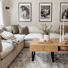 a living room with two pictures on the wall and a coffee table in front of it