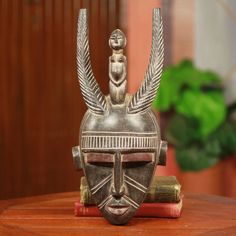 a metal mask sitting on top of a wooden table