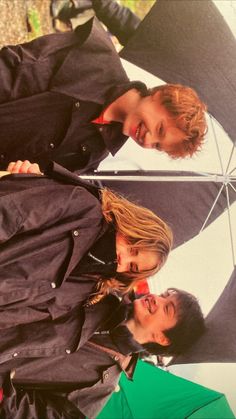 two men standing next to each other under an umbrella