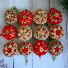 nine crocheted ornaments are arranged on a white wooden surface with red ribbons and green leaves