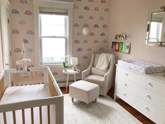 a baby's room with a white crib, rocking chair, and window