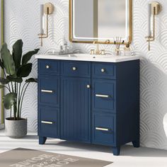 a bathroom with a blue vanity and gold accents on the wall, along with a white toilet