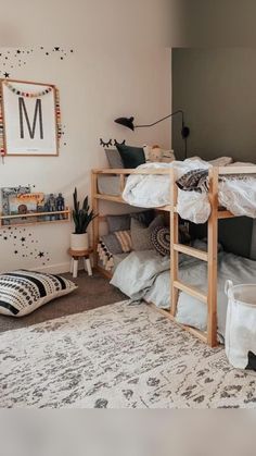 a bedroom with bunk beds and pillows on the floor in front of a wall mounted poster