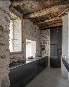 an empty kitchen with stone walls and flooring