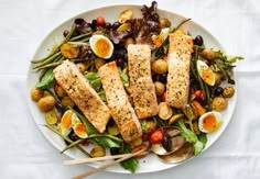 a white plate topped with salmon and veggies