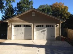 two garages are shown in front of a fenced in area with trees and bushes