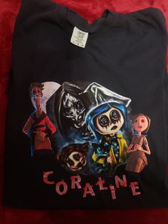 a black t - shirt with an image of the characters from coraline on it