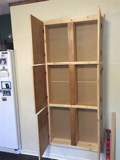 an empty shelf in the corner of a room next to a refrigerator and freezer