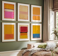 a living room filled with furniture and paintings on the wall next to a large window