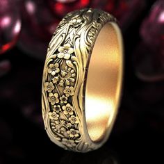 a gold wedding ring with flowers on it