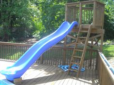 a blue slide in the middle of a wooden deck