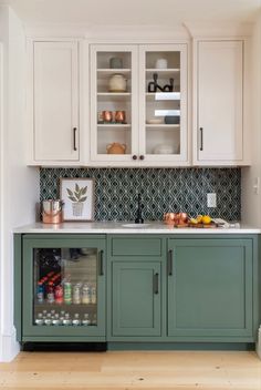 a kitchen with white cabinets and green cupboards