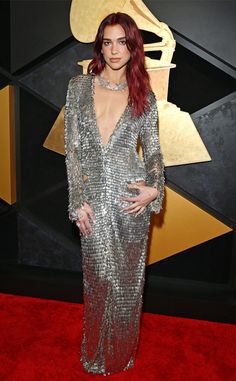 a woman with red hair in a silver dress on the red carpet at an awards event