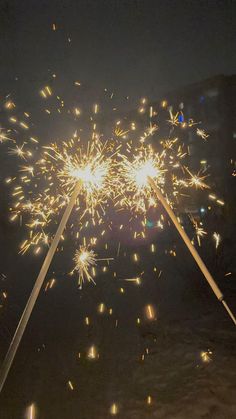 fireworks are lit up in the night sky with long white sticks sticking out from them