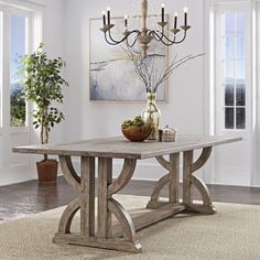 a dining room table with a chandelier hanging from it's centerpiece