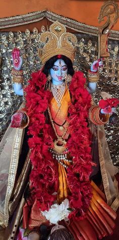 an idol is displayed in front of some other items and people are sitting on the floor