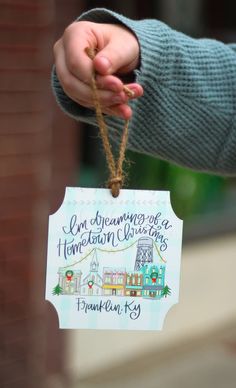 a person holding a christmas ornament in their hand with the words, i am dreaming about a home town christmas