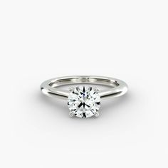 a white gold ring with a round brilliant cut diamond on the top, set in 18k white gold