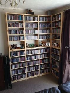 a living room filled with lots of bookshelves covered in dvd's and movies