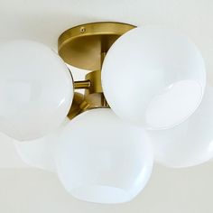 three white globe lights are hanging from the ceiling