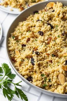 a bowl filled with rice and nuts on top of a table next to other dishes