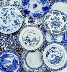 many blue and white plates stacked on top of each other