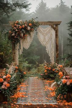 an outdoor wedding ceremony with flowers and macramicals on the aisle, surrounded by greenery