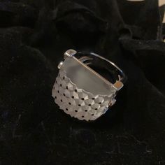 a silver ring sitting on top of a black cloth