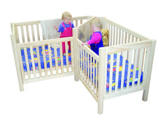 two small children playing in their cribs